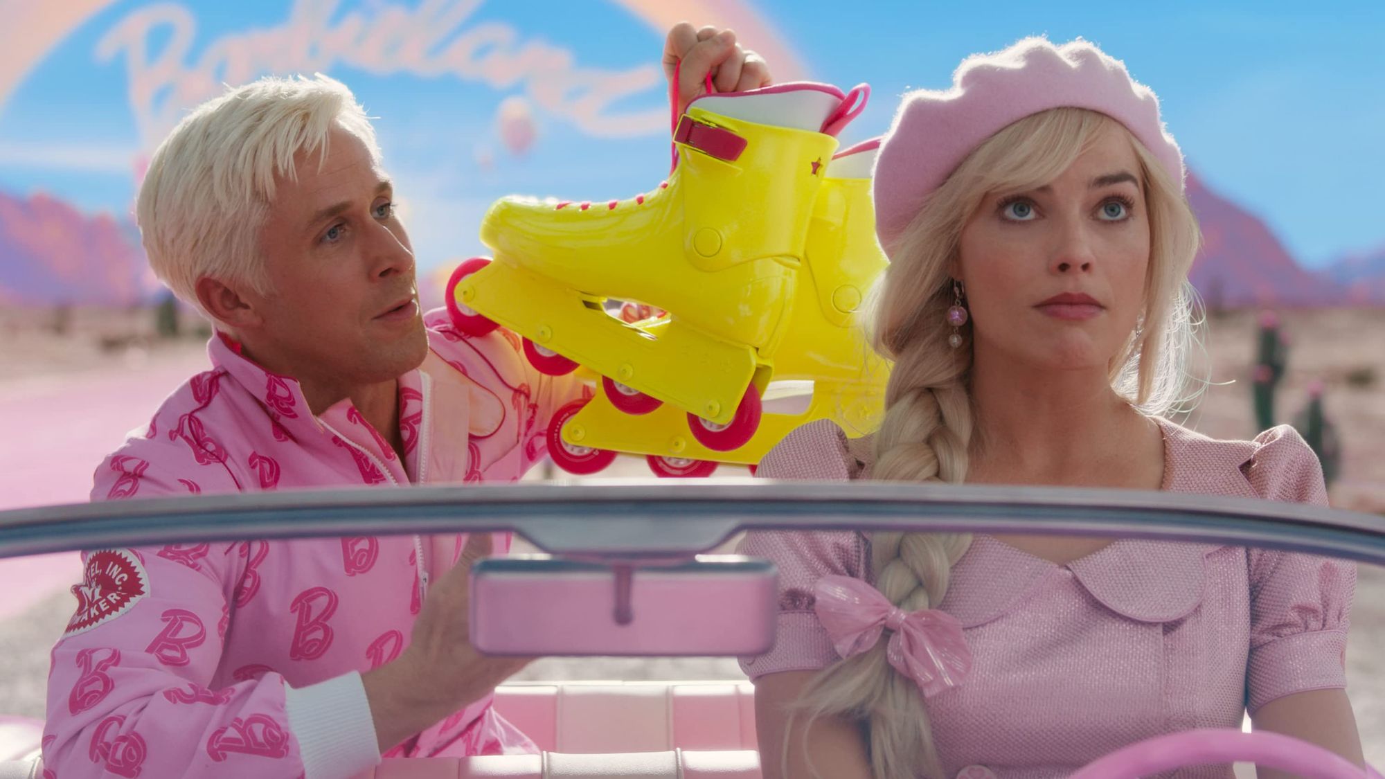 Ken (Ryan Gosling) pops up in the backseat of Barbie's (Margot Robbie) very pink, very small car, holding his neon yellow rollerblades.