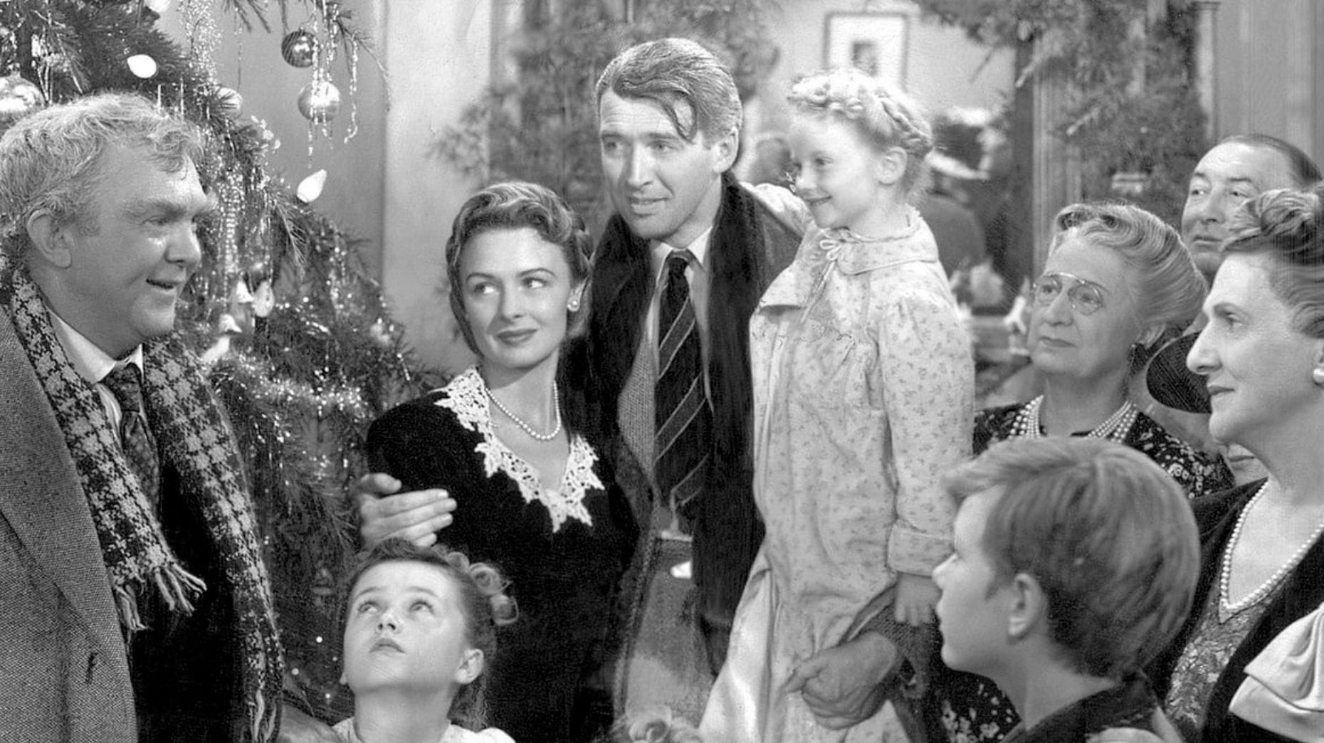 George Bailey, at center, listens to his Uncle Billy talk. He's joined by wife Mary; children Janie, Zuzu, and Peter; his mother; his mother-in-law; and some other guy who's probably Tom. A Christmas tree glistens in the background.