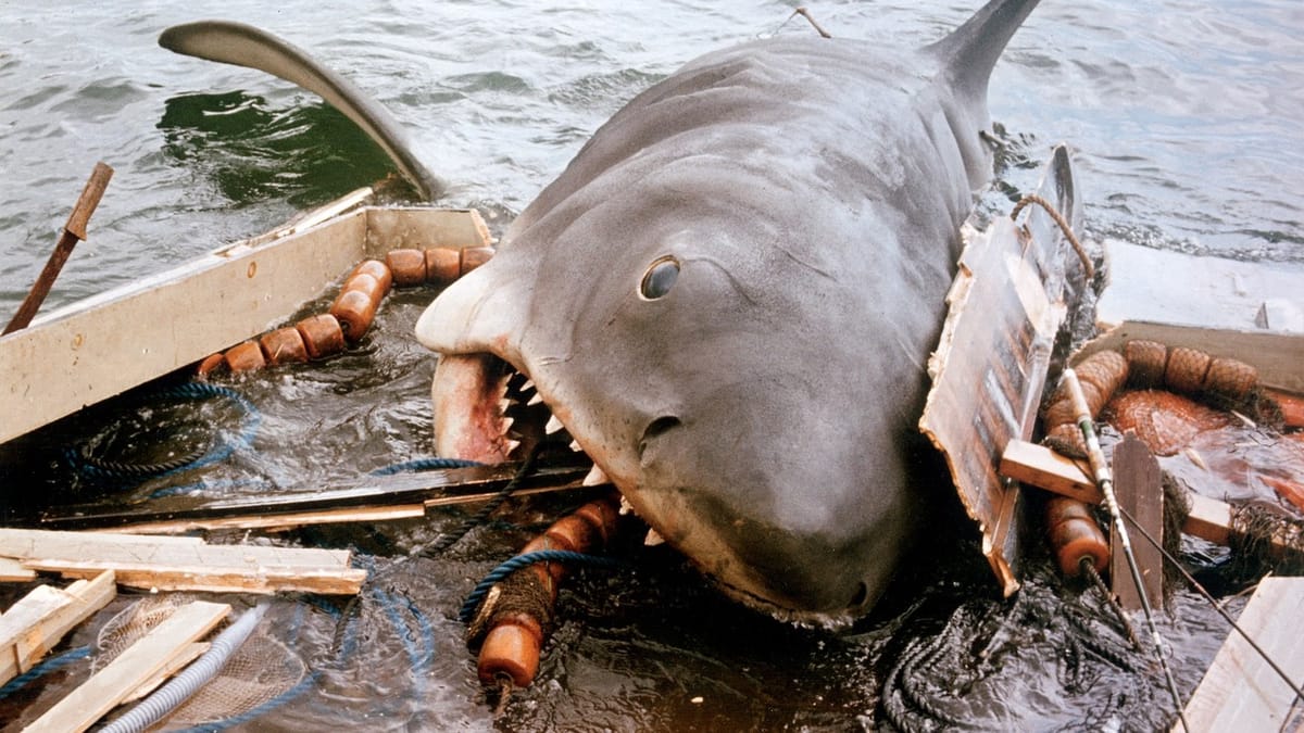 The shark from Jaws lunges up onboard a boat, gobbling away at the various pieces of flotsam and equipment there.