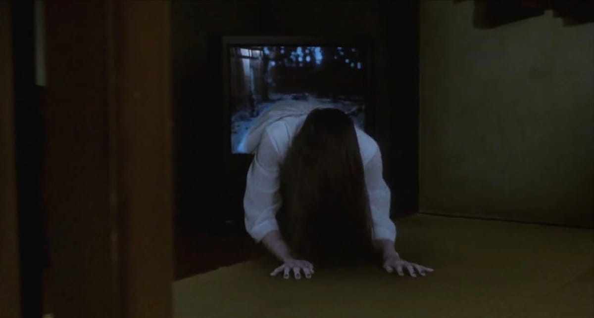 A girl crawls out of a television, long dark hair draped down so you cannot see her face.
