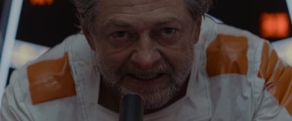 Kino Loy delivers an inspirational speech directly into the microphone, shot in tight close-up.