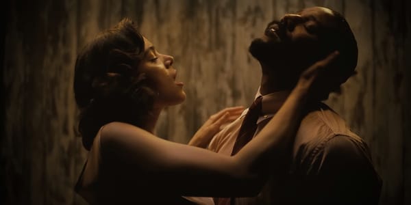 Hailee Steinfeld and Michael B. Jordan star in Sinners. They're in an embrace, heads tilted back in ecstasy, in a wood-paneled room.