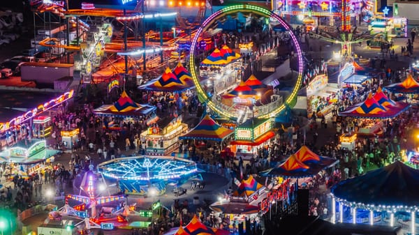 The midway at the Minnesota State Fair is full of rides and games, all glowing neon-bright in the night.