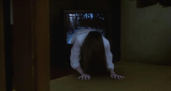 A girl crawls out of a television, long dark hair draped down so you cannot see her face.
