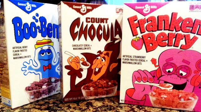 Old-fashioned boxes of Boo Berry, Count Chocula, and Franken Berry lined up on a kitchen counter.
