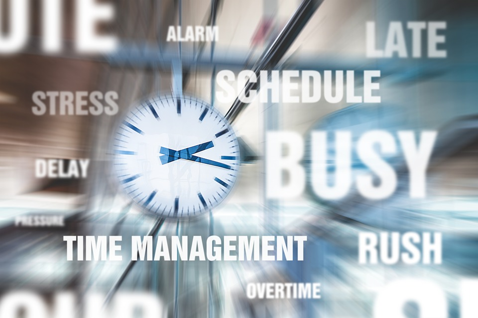 An out-of-focus clock is surrounded by the words ALARM, LATE, SCHEDULE, BUSY, RUSH, OVERTIME, STRESS
