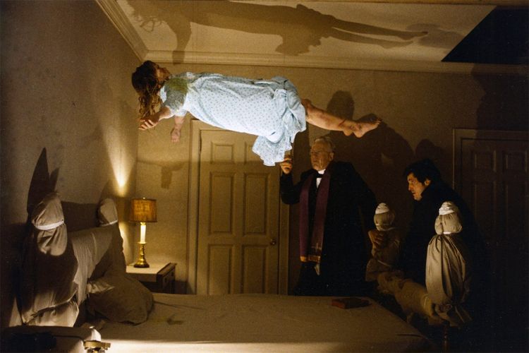 Regan floats into the air above her bed as Fathers Merrin and Karras perform their exorcism ritual.