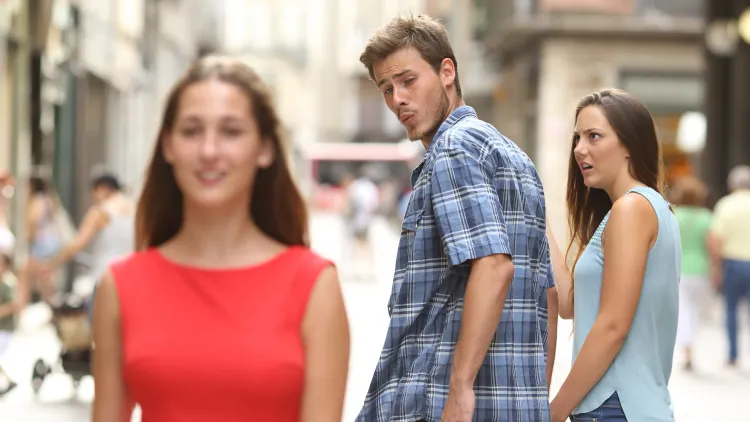 It's the distracted boyfriend meme! A guy looks at a girl in red as his girlfriend (in blue) looks disgusted with him.