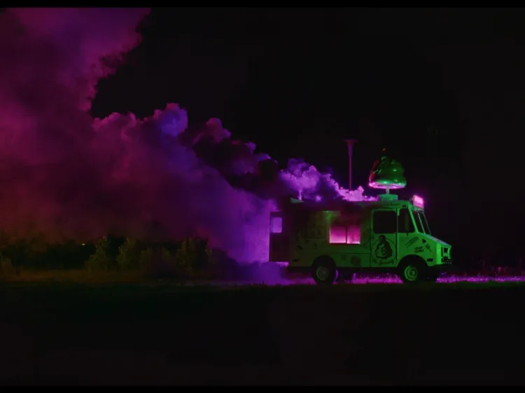 A stalled out ice cream truck sits in a black void, pink smoke billowing from it.