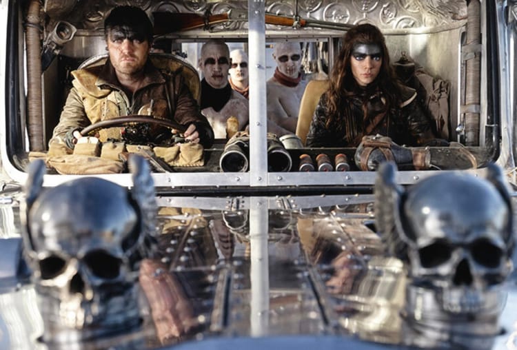 Furiosa and Praetorian Jack, joined by painted-white war boys, ride off in the enormous war rig.