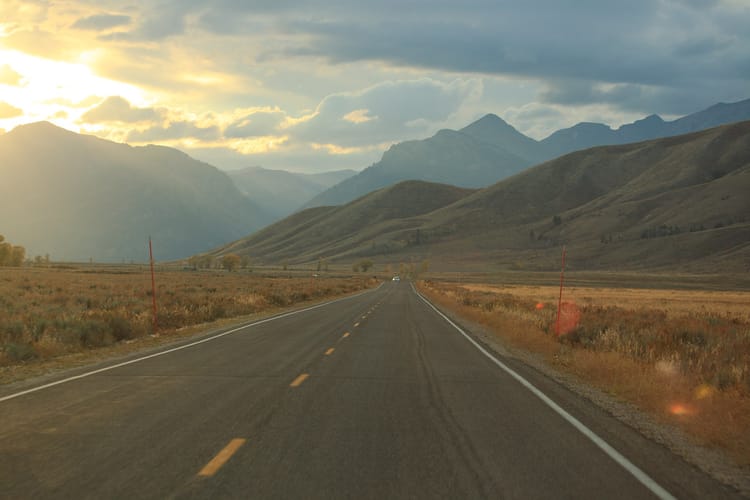 An open road traveling through the mountains.