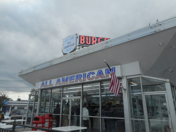 The All-American Hamburger Drive-In is a boxy little white building done up in red, white, and blue.