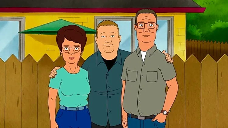The Hill family stands in their backyard in front of a wooden fence. Bobby is now as tall as his parents.